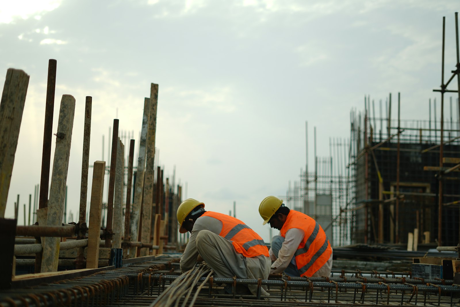 Construction workers in hard hats and safety vests working on an active building site